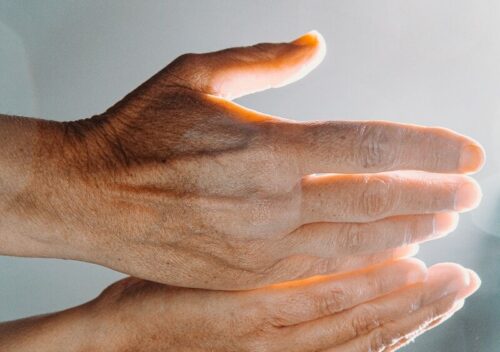 persons hand with white nail polish