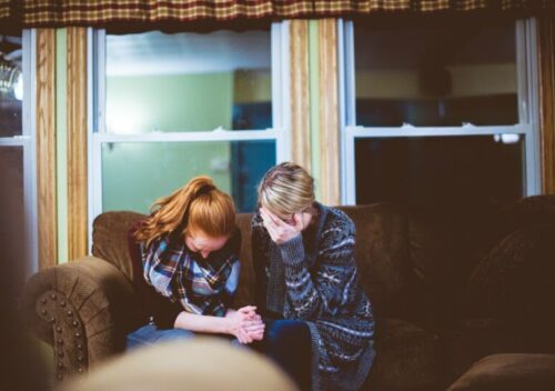 man and woman sitting on sofa in a room