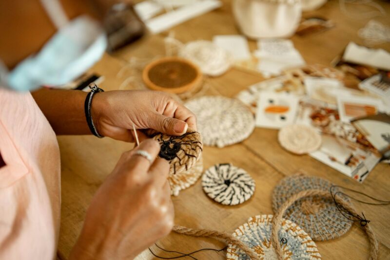 A woman is working on a piece of crochet