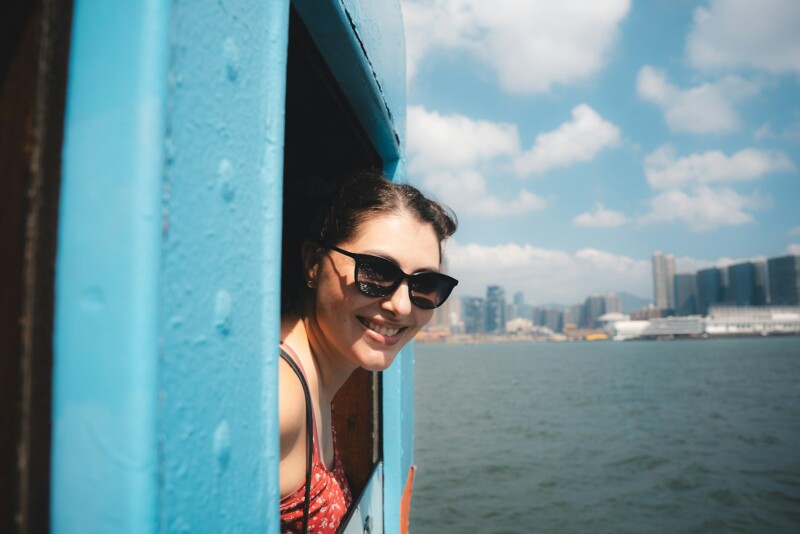 Young woman smiles from a blue window on a boat.